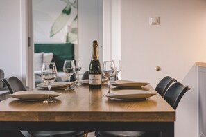 Ein Esstisch ist gedeckt mit Tellern, Gläsern und einer Champagnerflasche.