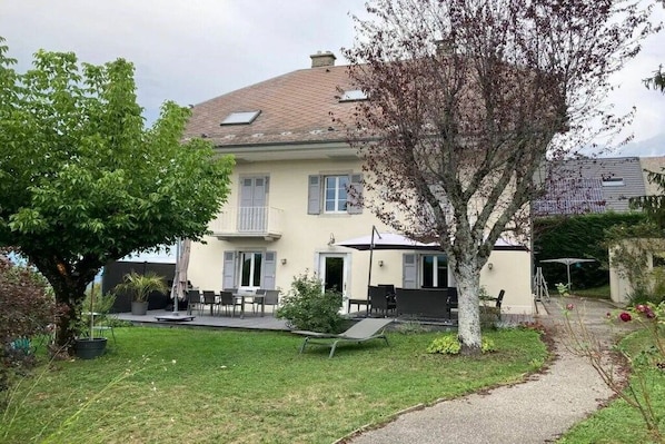 A two-story house with a patio area, outdoor seating, and a pathway leading to the entrance. - Holiday home in Trevigin with Wi-Fi (TREVIGNIN)