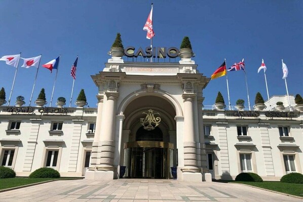 A grand entrance with a 'CASINO' sign, multiple national flags, and a classical architectural style. - Apartment with 1 bedroom (Aix les Bains)