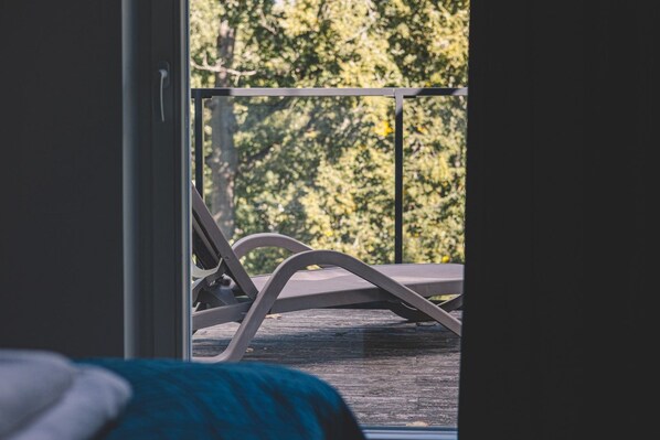 A balcony with a metal railing and a view of trees.