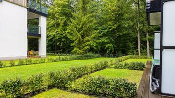 Ein gepflegter Garten mit ordentlich geschnittenen Hecken und verschiedenen Bäumen.