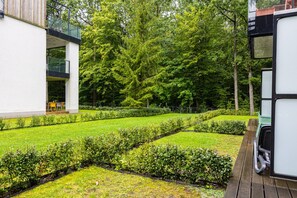 Un jardí ben cuidat amb setges ben podades i diferents arbres.