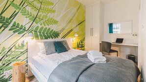 Une chambre à coucher moderne avec un lit, un bureau et une chaise.