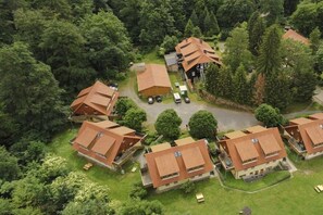 Eine Ansammlung von Häusern mit geneigten Dächern, umgeben von dichtem Grün.