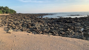 Ein felsiger Strand bei blauem Himmel.