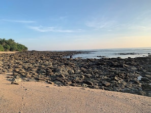 Una playa rocosa con cielo despejado.