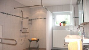 A bathroom with a shower, a toilet, a sink, and a window with a view. - "To the dike warden" (Losheim am See)