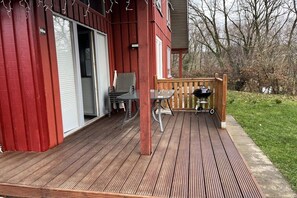 A wooden deck with a barbecue grill, a table, and chairs. - Holiday home in Extertal-Rott with barbecue (Extertal-Rott)