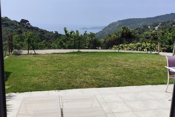 A grassy outdoor area with a view of hills and a body of water. - Holiday apartment in Èze with swimming pool (Èze)