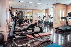Ein Fitnessstudio mit unterschiedlichen Trainingsgeräten, darunter Laufbänder, Ergometer und Kraftgeräte.
