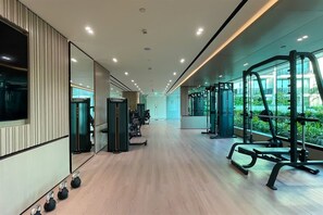 A gym with exercise equipment, a wooden floor, and large windows. - Stylish JVC Studio at Binghatti Aurora, Dubai (Dubai)