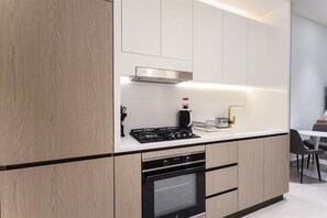 Una cocina moderna con horno empotrado, cocina a gas y cafetera.