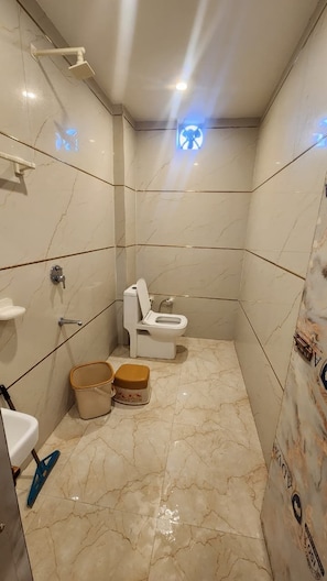 Un baño con inodoro, ducha y lavamanos.