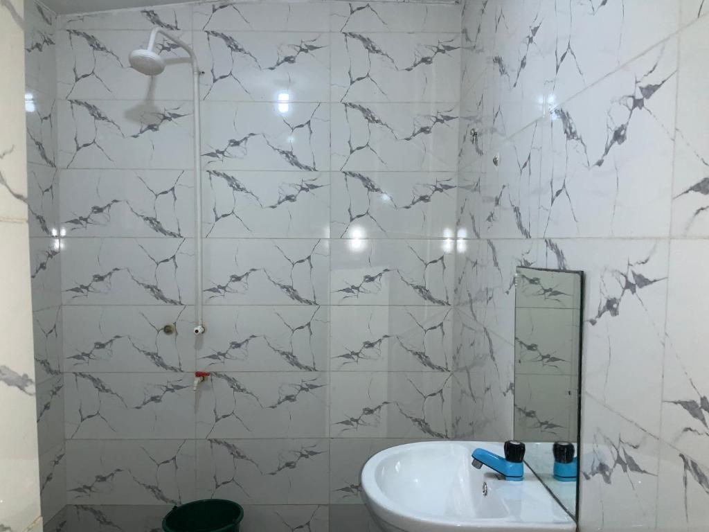 Un bany amb dutxa, un lavabo i un mirall.