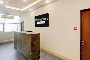 Een receptiebalie met een bordje waarop staat dat het een bedrijfsservicetownhouse is.