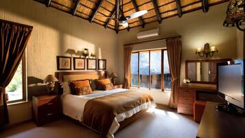 A hotel room with a bed, bedside tables, a TV, a wardrobe, and a large window with curtains.