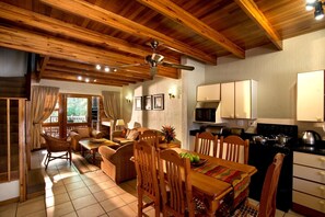 A cozy interior with a dining area, kitchen, and seating space. - Kruger Park Lodge by First Private Stays (Hazyview)