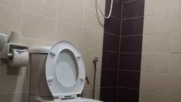A toilet with a paper towel holder and a hand dryer.