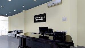 En receptionsdisk med en dator, en skylt som visar att det är ett radhus som tillhandahålls av företaget, och ett fönster med utsikt.