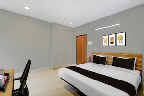 A hotel room with a bed, a desk, and a chair. There are three framed pictures on the wall. - Super Townhouse Cherlapally Bus Terminal (Hyderabad)
