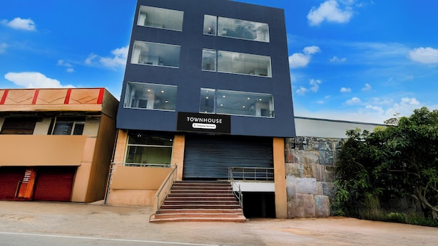 En modern byggnad med en skylt som visar texten: ”TOWNHOUSE – företagstjänster”.