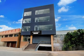Um edifício moderno com uma placa indicando 'TOWNHOUSE' e uma escadaria que leva a uma entrada.