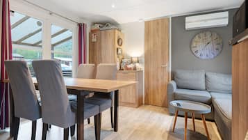 Un interior moderno con comedor, sofá y un reloj de pared.