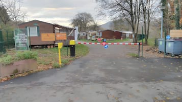 Une entrée fermée par un portail mène à une propriété où un panneau indique qu’il s’agit d’une maison mobile.