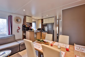 Una cocina moderna con comedor, sofá y vistas al exterior.