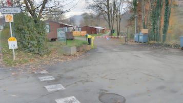 Eine Straße, die zu einem Campingplatz führt, mit einem Stoppschild, einem Wegweiser und einer Fußgängerquerung.