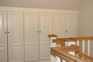 A staircase with wooden handrails and white walls. - Holiday apartment in Sylt with 2 bedrooms (Sylt \/ OT Westerland)