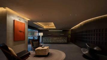 Eine moderne Lobby mit einer Sitzecke, einem Empfangsbereich und einem großen Fenster.