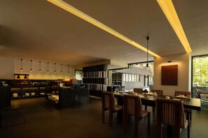 Un interior moderno con comedor, cocina y un ventanal que proporciona luz natural.