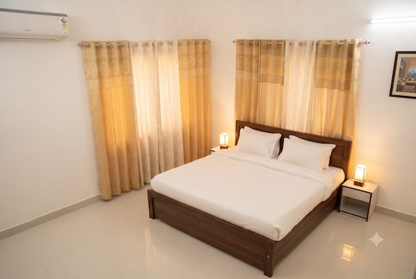 A hotel room with a wooden bed, two bedside tables with lamps, and a large window with curtains.