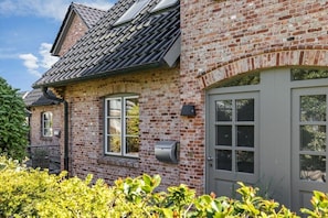 A brick house with a grey door, a window, and a mailbox. - Holiday home in Sylt with 3 bedrooms (Westerland)