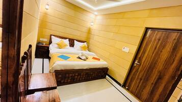 Una habitación de hotel con cama, mesita de noche y armario.