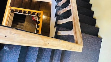 A spiral staircase with a wooden handrail and black steps.