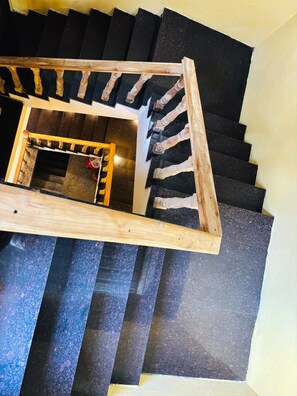 Una escala de caragol amb barana de fusta i graons negres.