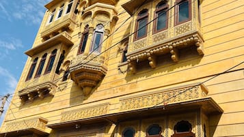 A multi-story building with ornate architectural details, including carved balconies and windows.