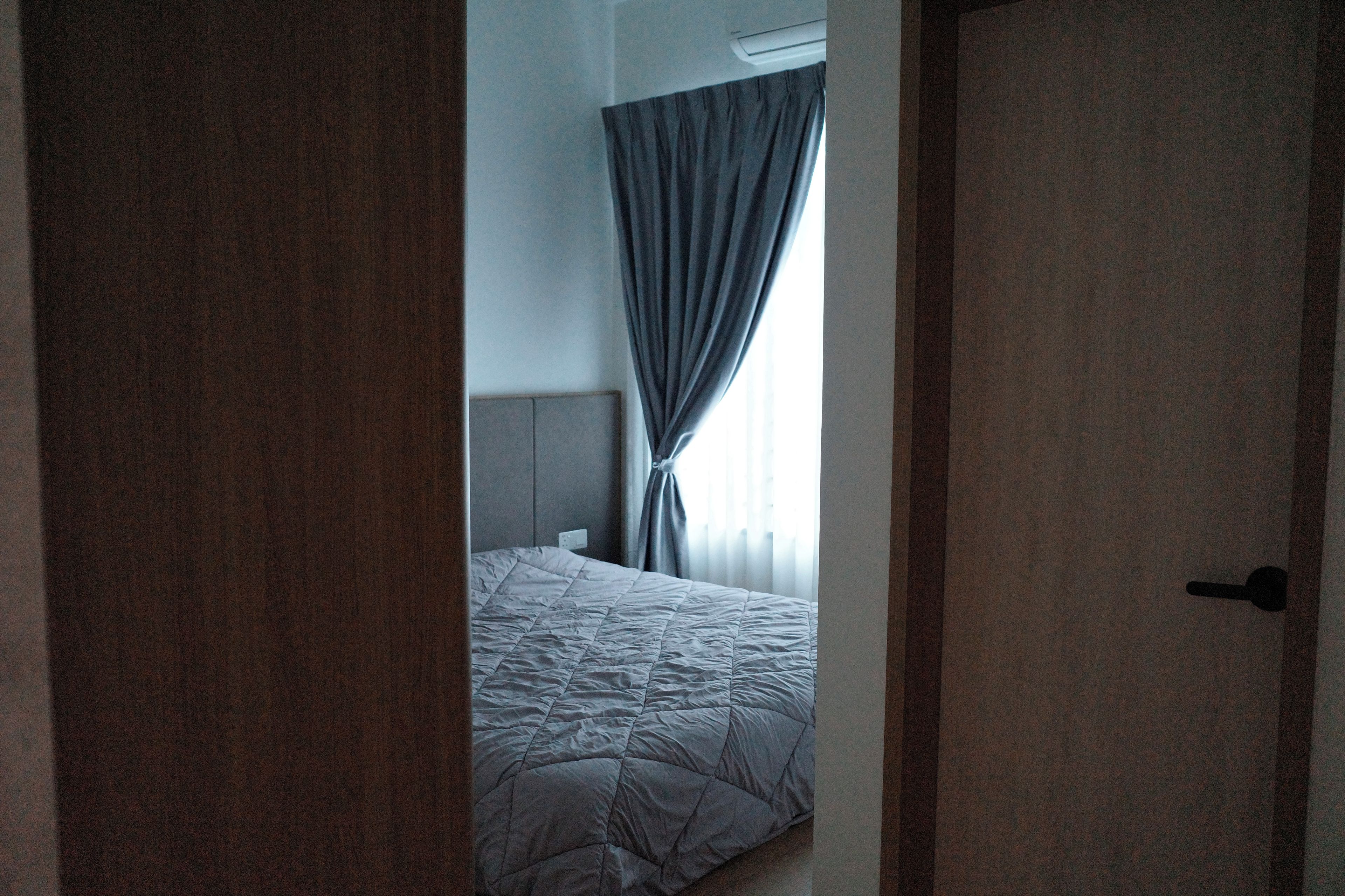 Un dormitorio con cama, cortinas y una puerta.