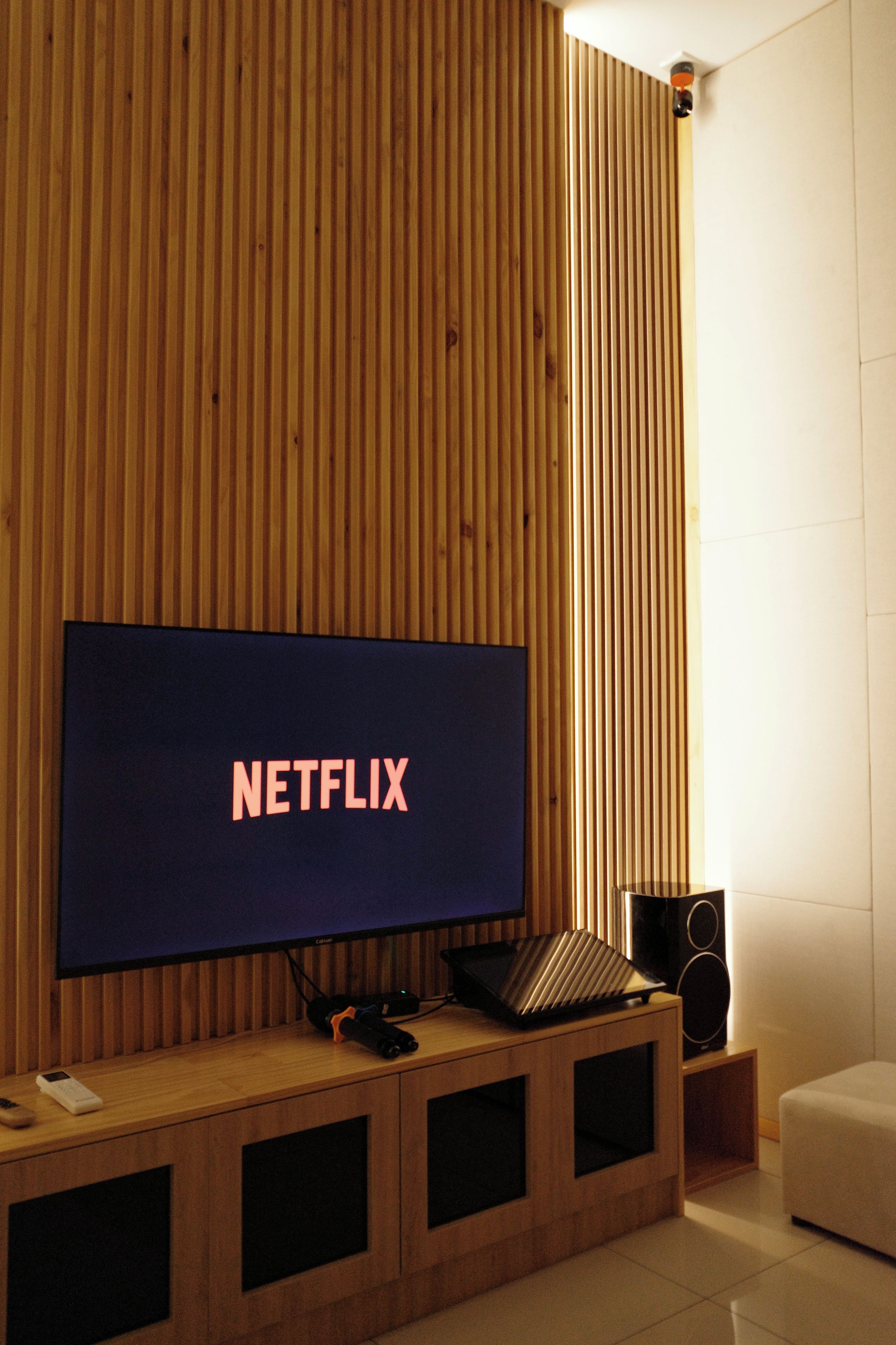 A television with the Netflix logo on a wooden wall.