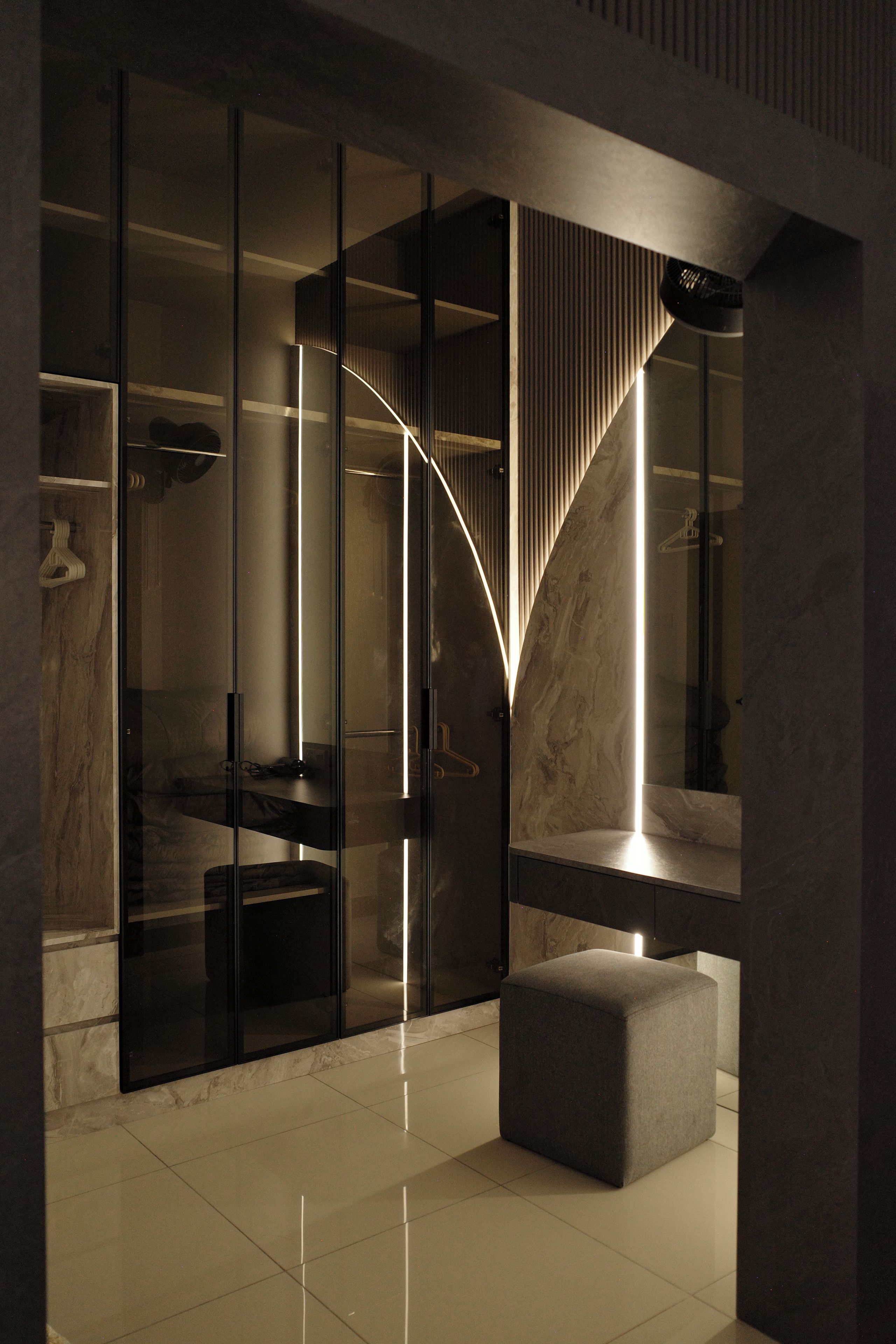 Ein modernes Interieur mit einer Glastrennwand, einer Marmorwand und einer Sitzbank.