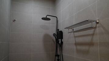 A shower area with a handheld showerhead, a wall-mounted towel rack, and a control unit.