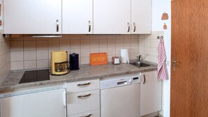 A kitchen with white cabinets, a coffee maker, a toaster, and a dish rack. - Holiday apartment with 2 bedrooms (Cuxhaven)