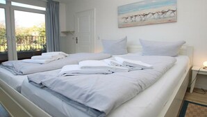 Een hotelkamer met een groot bed, een schilderij aan de muur en uitzicht op het landschap.