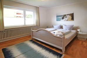 A bedroom with a bed, a window, a radiator, and a painting on the wall. - Linge 4, Holiday Apartment 1, Hygge (Wrixum)