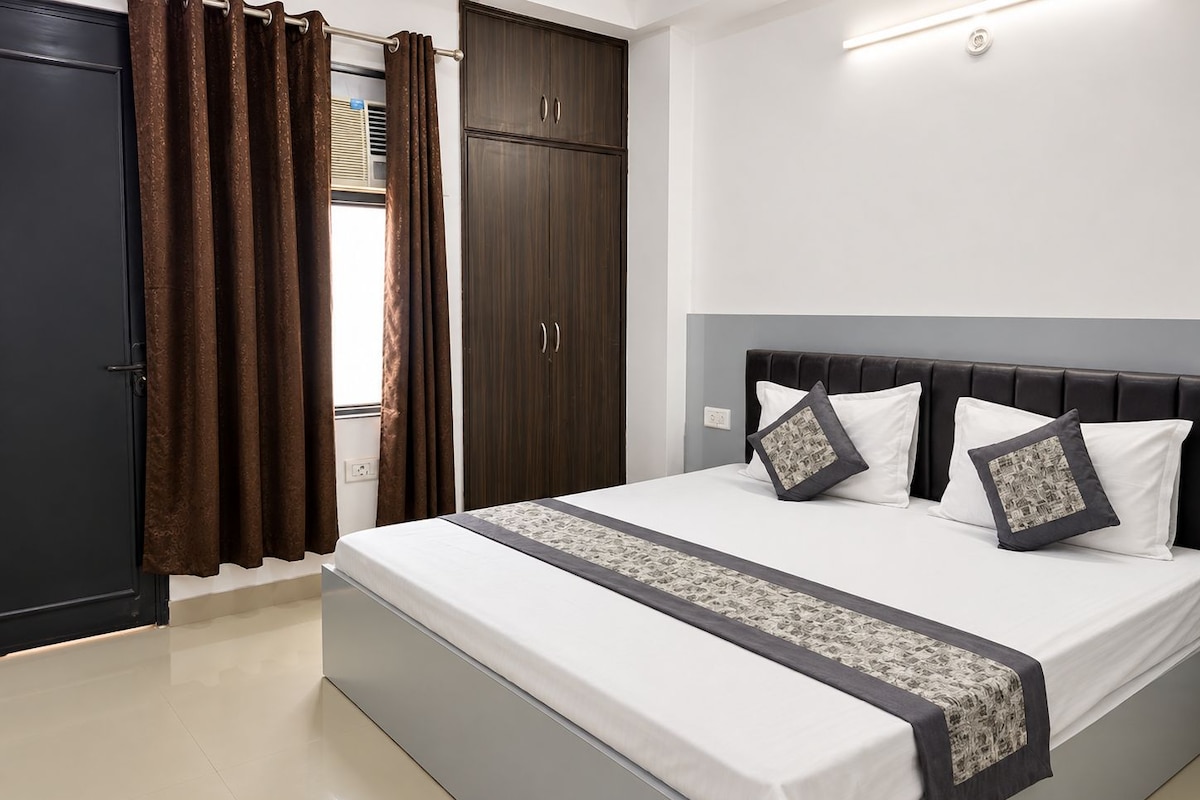 Une chambre à coucher avec un lit, des rideaux, une armoire et une table de chevet.