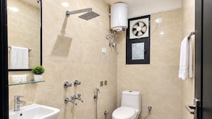 Un baño moderno con ducha, inodoro, lavamanos y espejo.