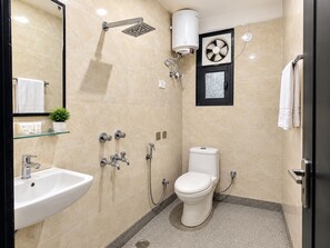 Une salle de bain moderne équipée d’une douche, de toilettes, d’un lavabo et d’un miroir.