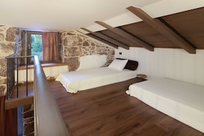 A bedroom with a stone wall, wooden beams, a window with curtains, and two beds. - Villa in Kornic, Krk with swimming pool (Kornic, Krk)